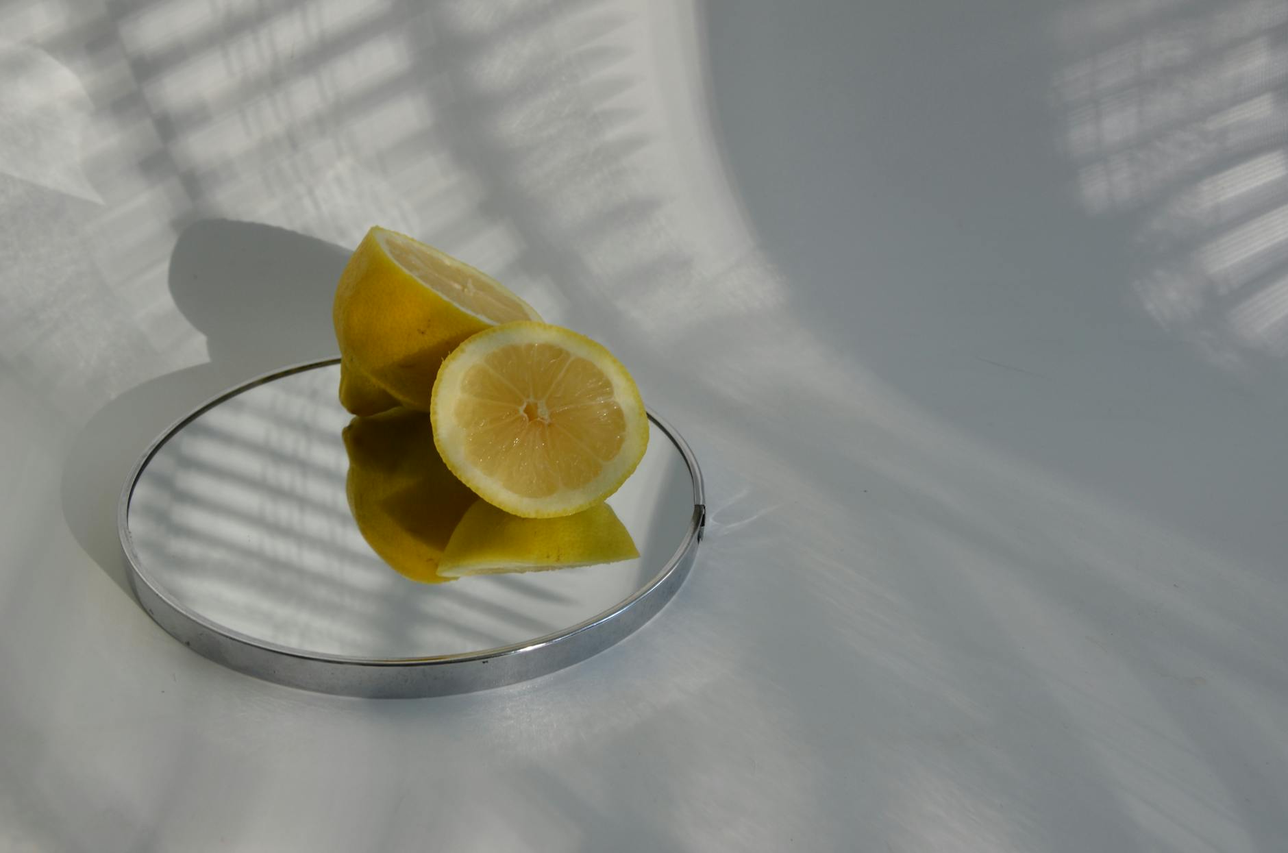 A hand holding a fresh lemon on a soft pink background, symbolizing the clitoral focus approach in partnered sex.