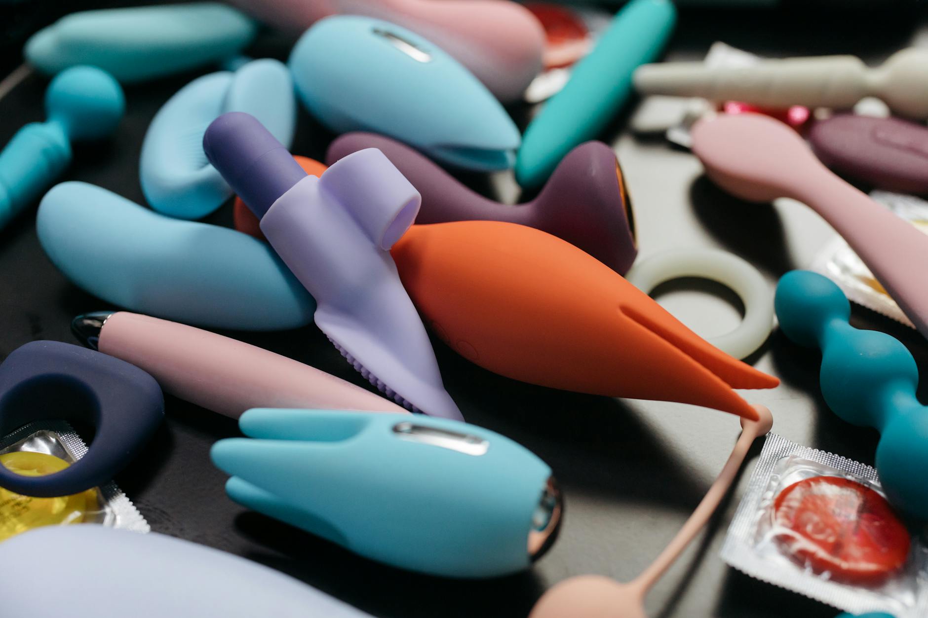 A person holding colorful vibrators against a purple background, representing tools for restoring sensation and pleasure