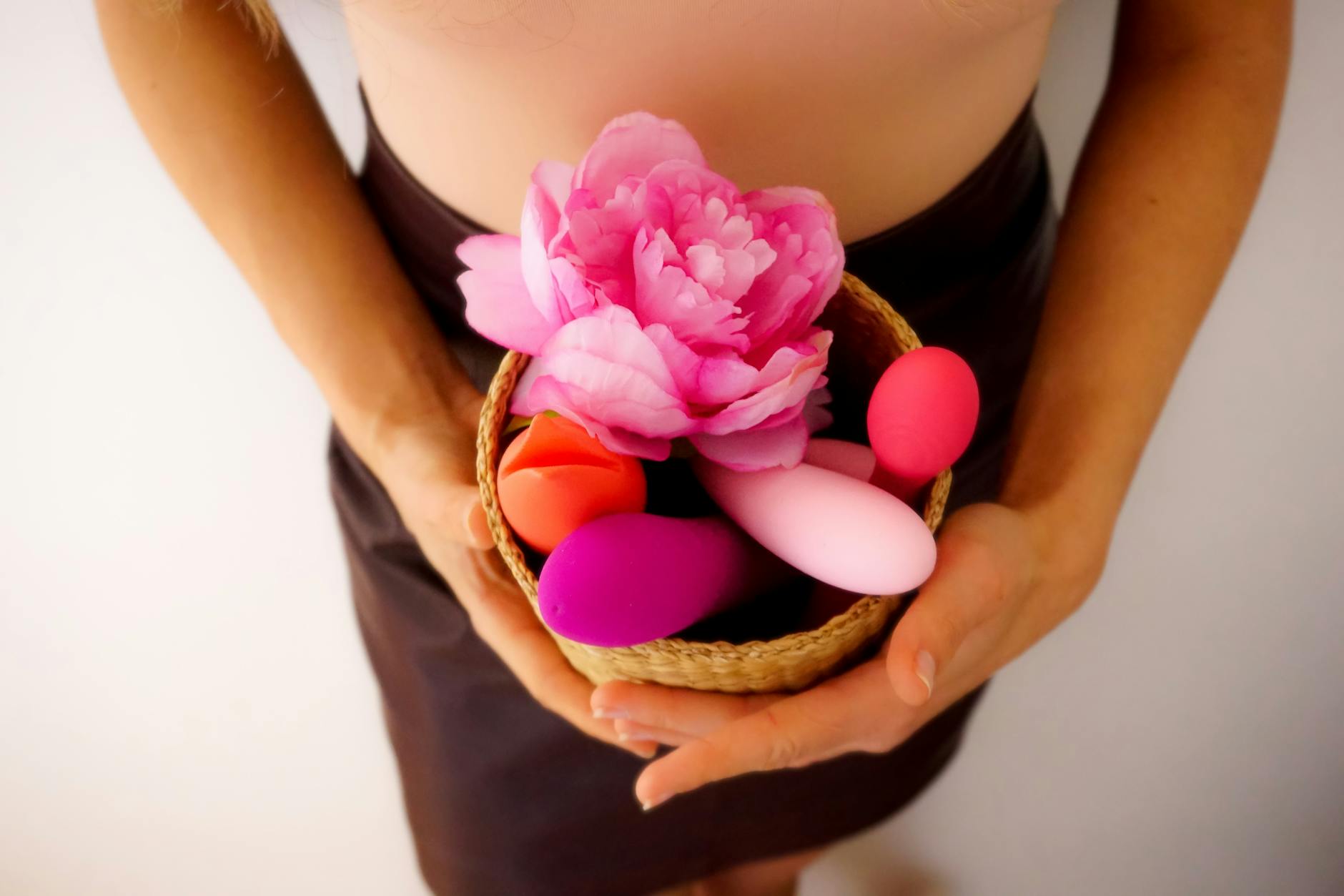 A young woman confidently holding a colorful vibrator, representing self-exploration and sexual empowerment